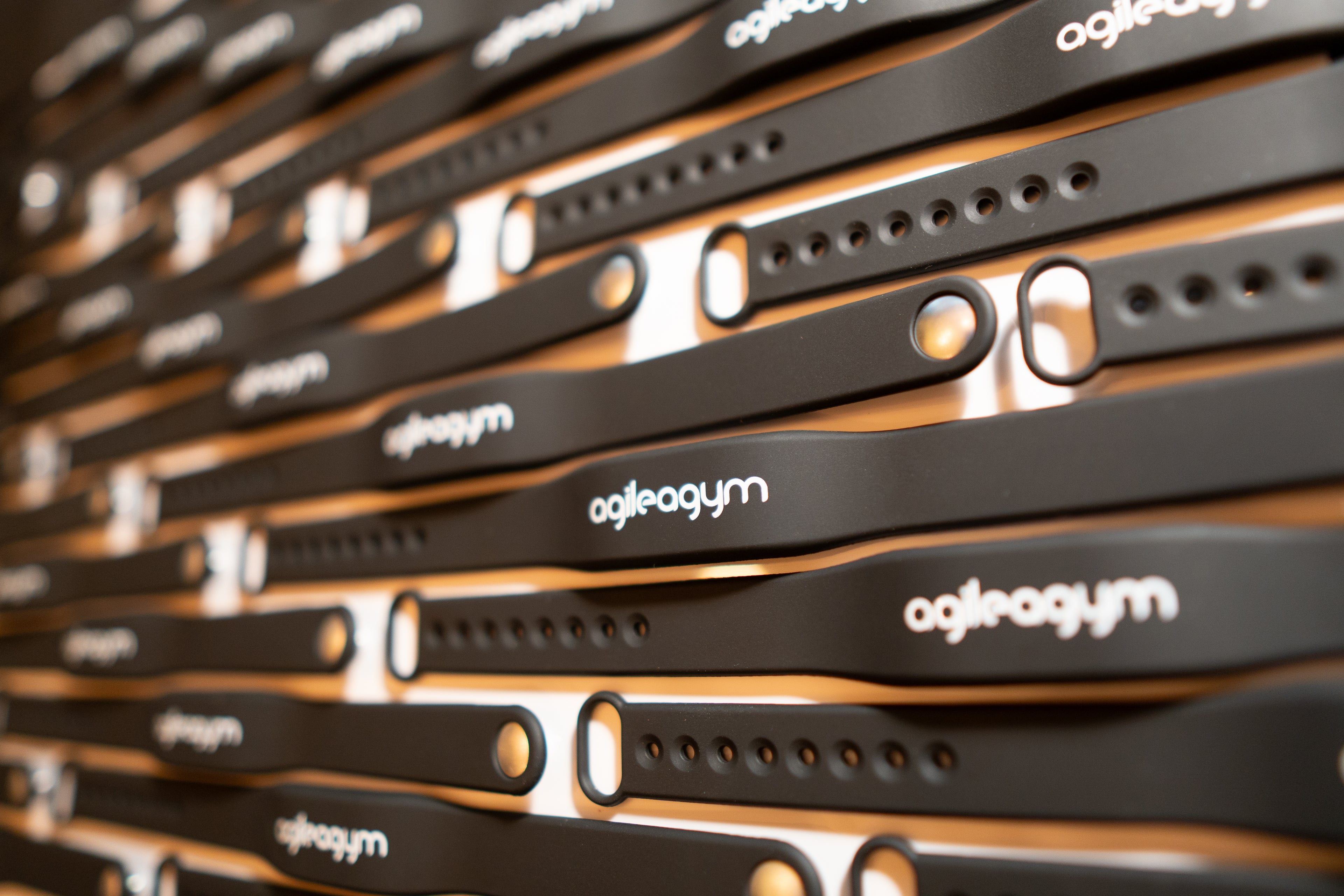 Rechteckiges Bild von in Reihe liegenden Transponder-Armbändern mit agilea Branding