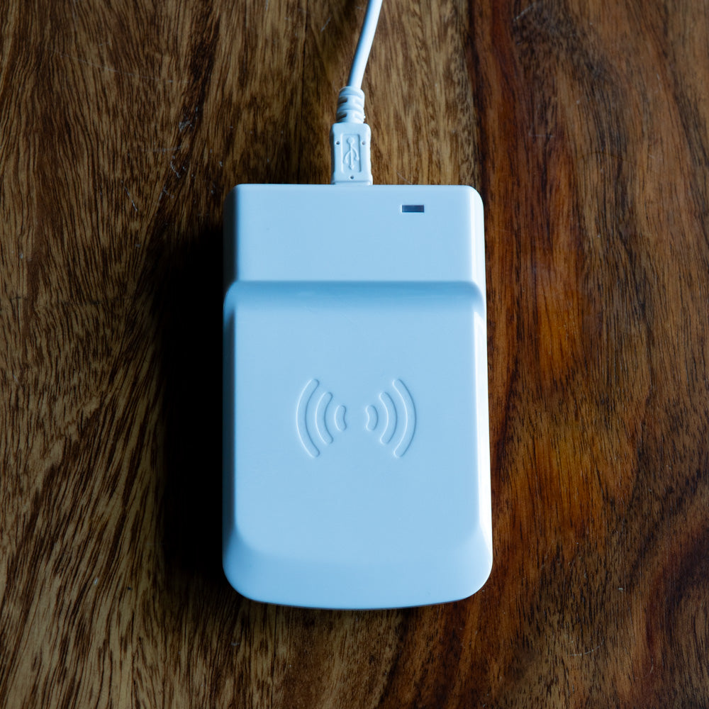 Foto eines USB-RFID Zuweisungsgeräts, welches auf einem Holztisch liegt 